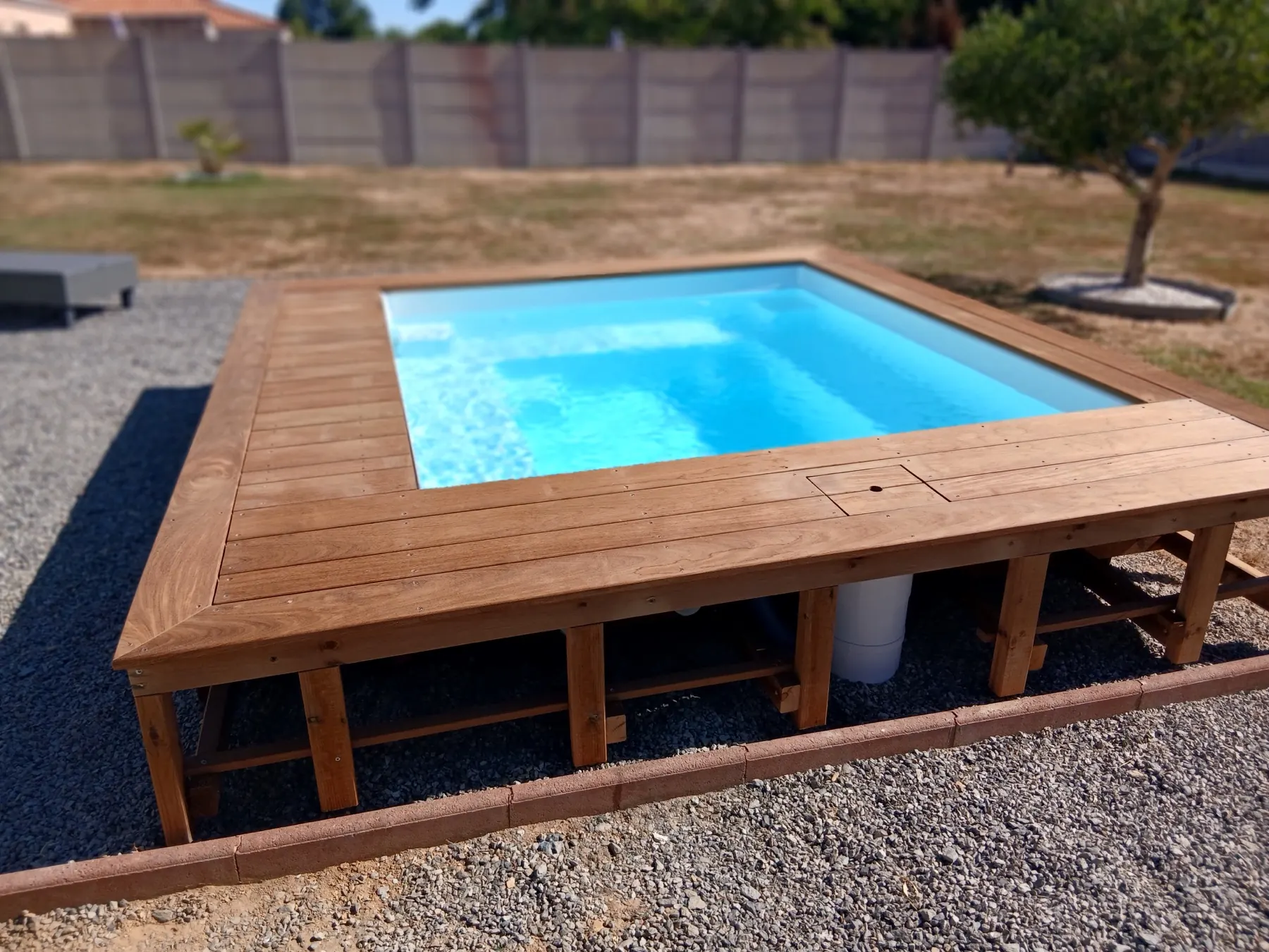 Vue d’ensemble de la structure et des plages en bois autour de la piscine